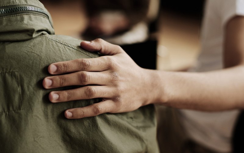 one man comforting another in group therapy
