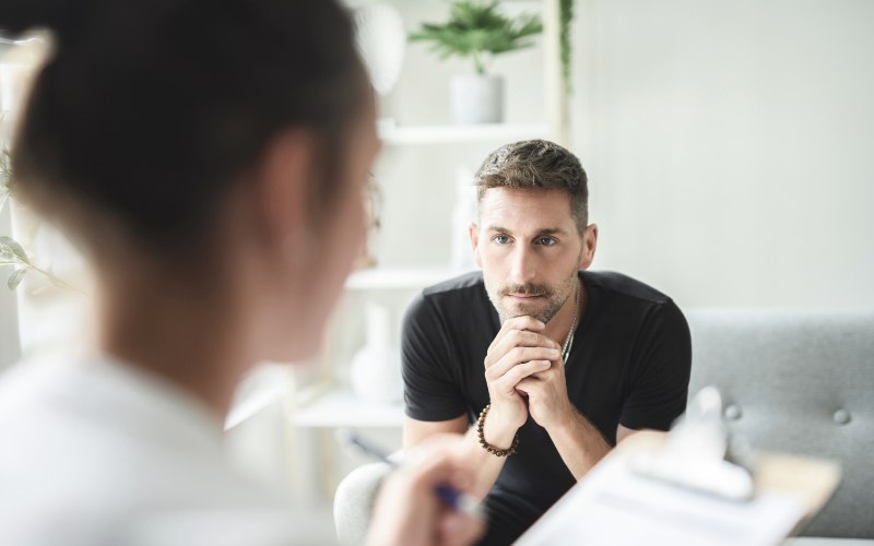 young man discussing drug use with his therapist